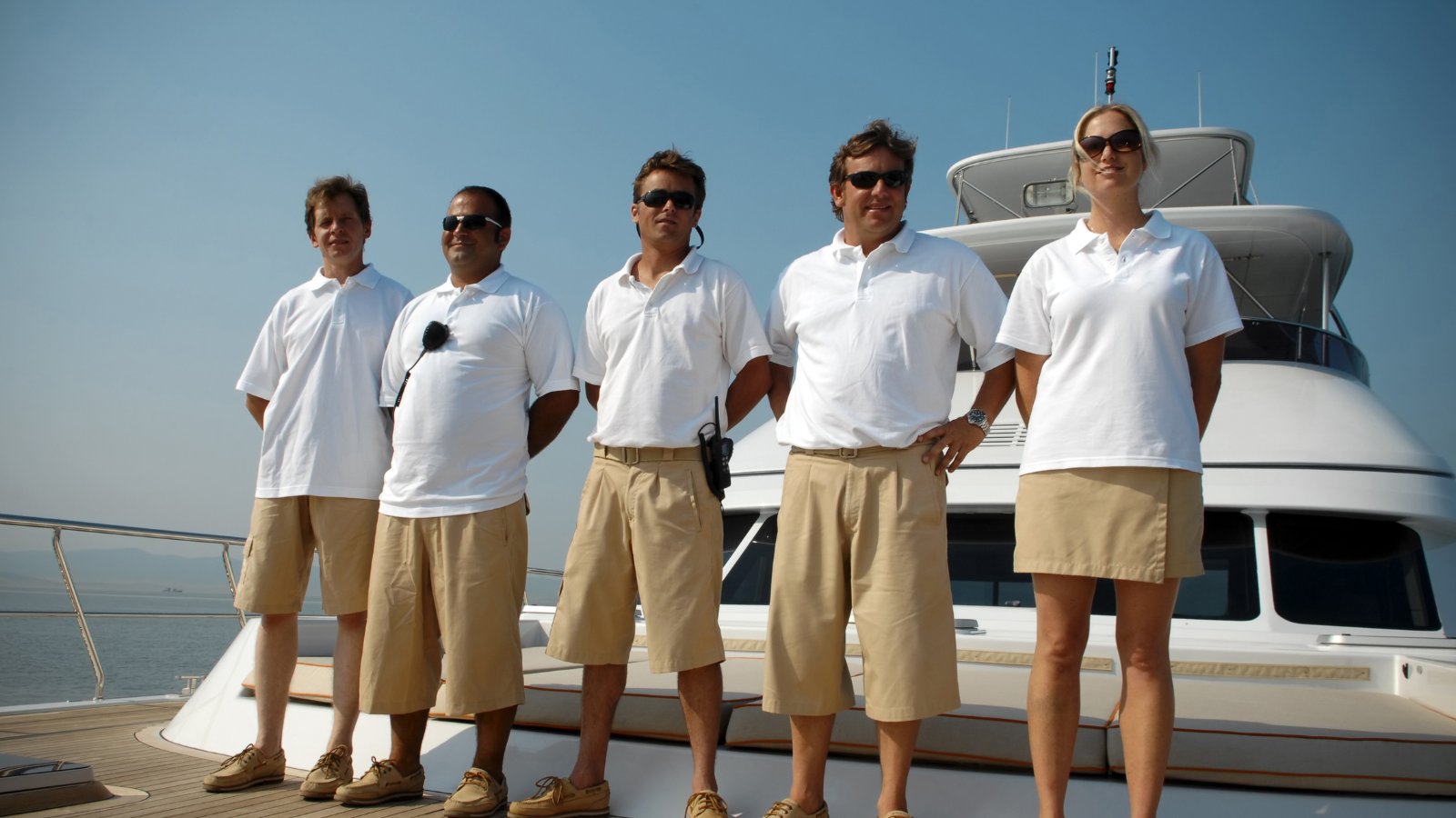 Multicultural yacht crew standing together on a superyacht